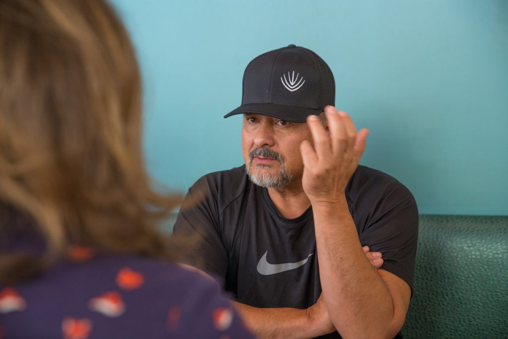 Man with black hat and black shirt in conversation