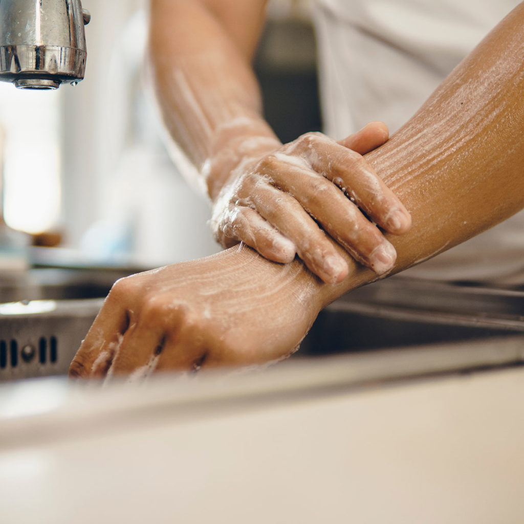 Man washing hands in commercial sink
