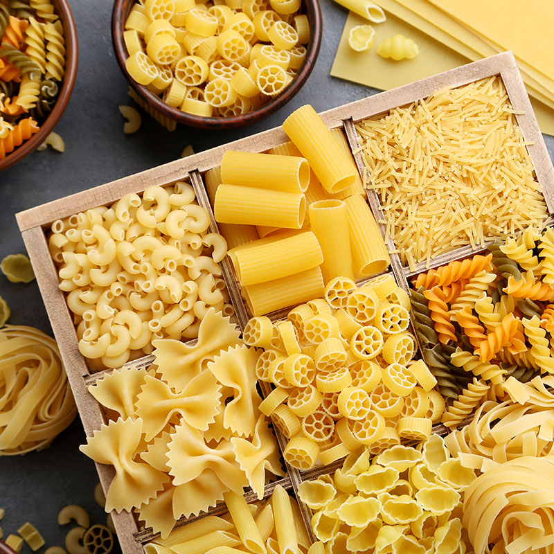 Looking down at a table full of pasta varieties in bins and containers. 
Three Timesaving Products We’re Thankful For