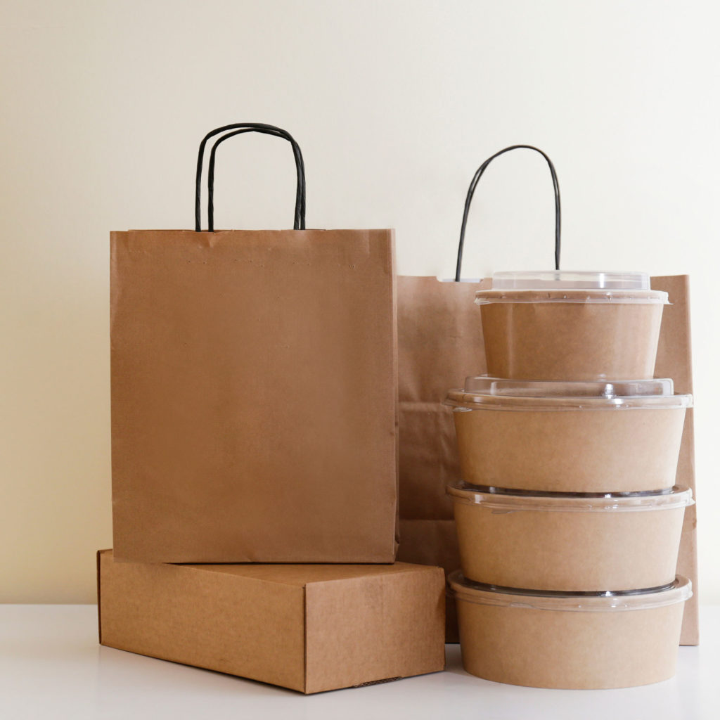 To-go bags and takeout containers stacked and ready for pick up